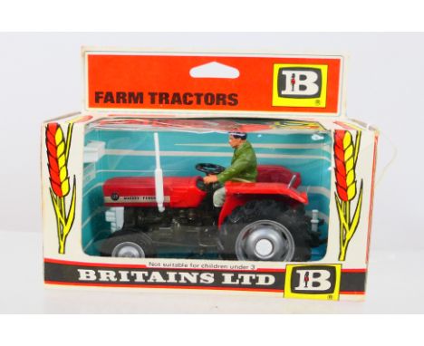 Britains - A boxed Britains #9520 Massey Ferguson Tractor. The model in red, with grey wheels and drive figure appears to be 