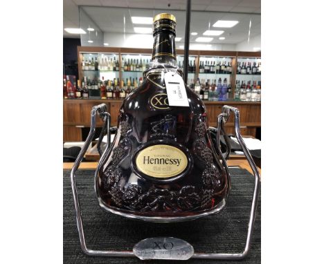 A DISPLAY BOTTLE OF HENNESSY COGNAC XO - ONE 3 LITRE BOTTLE, on a chrome stand, This is not for consumption, the bottle does 