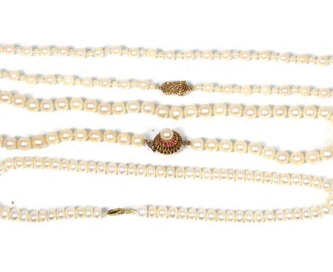 A cultured pearl necklace with a ruby set clasp, length 45cm, a cultured pearl necklace with a scroll clasp and another cultu