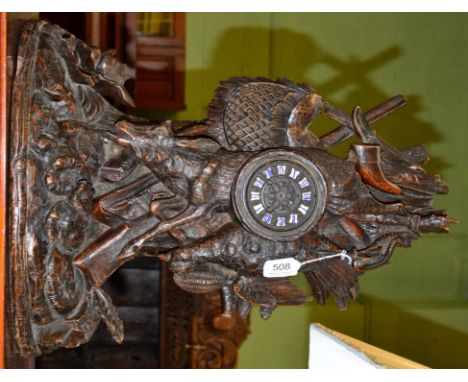 A carved black forest striking mantel clock, circa 1880, carved case depicting a hunting theme, floral decorated base, cast d