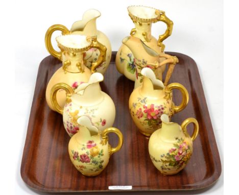 A collection of various Royal Worcester blush ground ewers and jugs, floral painted, gilt embellished (8)