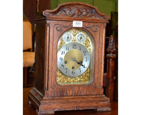 An oak bracket clock with brass and silvered Arabic dial
