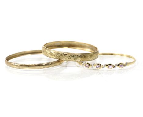 A 9 carat gold amethyst and diamond bangle, a 9 carat gold foliate engraved hinge opening bangle and another bangle, stamped 