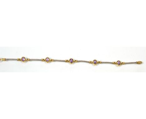 A 9 carat white and yellow amethyst bracelet, oval cut amethyst in yellow gold settings, spaced by white gold twisted bar lin