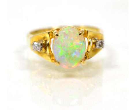 An opal and diamond three stone ring, an oval cabochon opal spaced by diamonds, finger size J, stamped '585', 3.8g