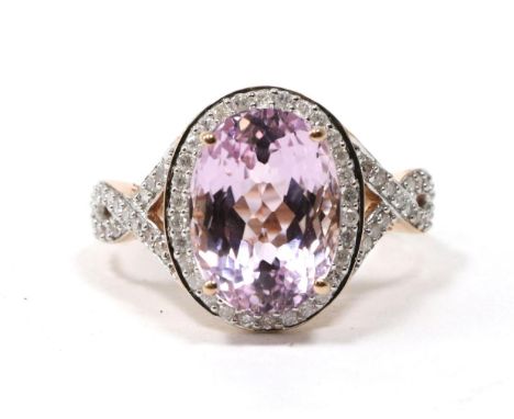 A 14 carat rose gold kunzite and diamond cluster ring, an oval cut kunzite within a diamond border, to diamond set scroll sho