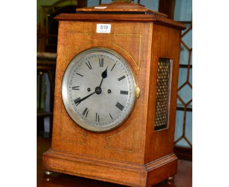 An oak bracket clock with silvered Roman numeral dial