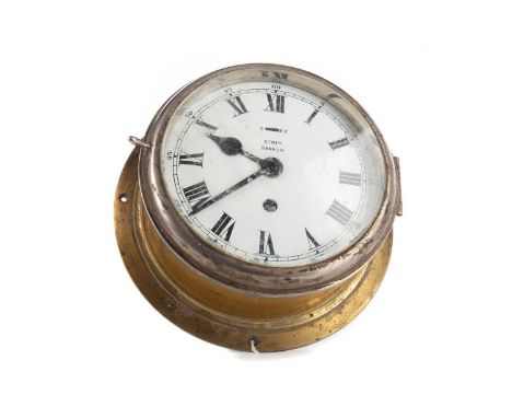 BRASS CASED SHIP'S BULKHEAD CLOCK BY STORY OF BARROW,the white enamel dial set with Roman and Arabic numerals and signed, 24c