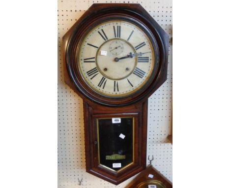 A late 19th Century American stained wood cased drop dial wall clock with seconds dial, roman numerals and visible pendulum, 