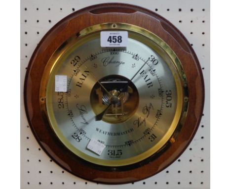A late 20th Century Weathermaster stained and moulded wood framed circular wall barometer with visible aneroid works to dial 