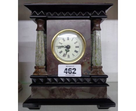 A small early 20th Century marble, black slate and granite cased timepiece of architectural design with four faceted tapered 