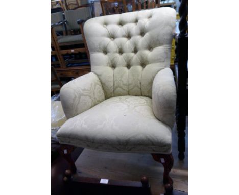 A reproduction stained wood framed button back armchair, upholstered in frosted lime tapestry, set on carved cabriole legs