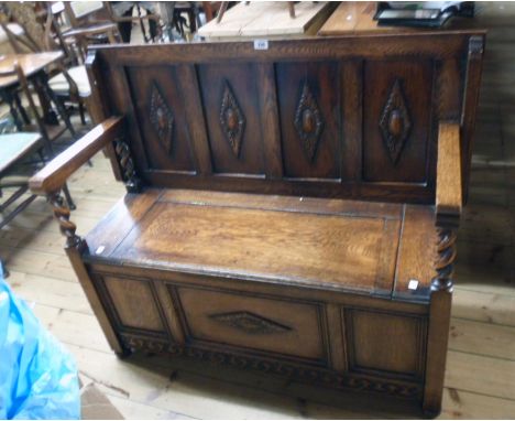 A 3' 9" 20th Century polished oak monk's bench with decorative four panel back and flanking twin barley twist supports, locke