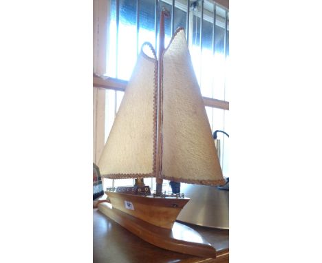 A vintage polished wood table lamp in the form of a yacht