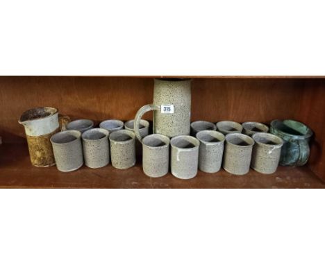 SHELF OF POTTERY CUPS &amp; WATER JUGS