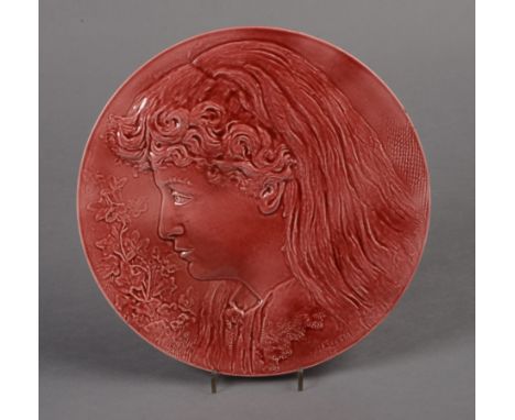 A BURMANTOFTS ART POTTERY PLAQUE of circular form, moulded in relief with a shoulder length portrait of a young girl, signed 