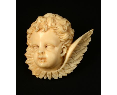 A VICTORIAN IVORY CHERUB BROOCH, carved in three-quarter relief with wing-wrapped collar, silver fittings by William Hair Has