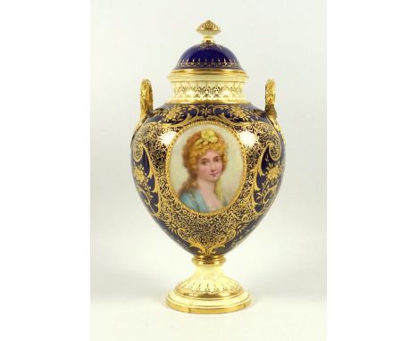 A Coalport porcelain twin handled ovoid vase and cover, the dark blue ground highlighted with elaborate gilding set with an o