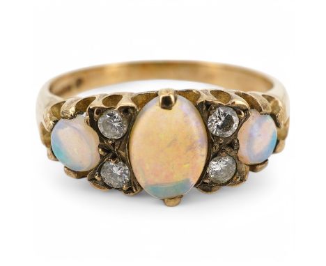 A modern 9ct gold, three stone white opal and four stone diamond set half hoop ring, size N, gross weight 2.4 grams.