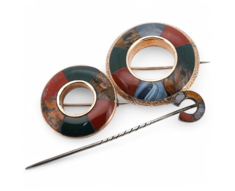 Two Scottish hardstone brooches and a stick pin, late 19th century, the brooches of annular design, the stick pin of horsesho