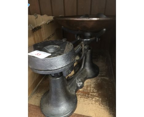 A cast iron scale with copper tray and weights 