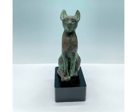 This Bastet cat god sits elegantly and straight on a black wooden base. The tail lies resting nestled against the body next t