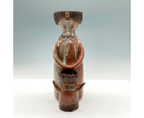 Figurative art pottery vase modeled as mother and child. This piece has a humble and simplistic design with impressed circula