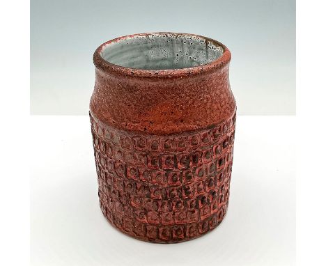 Wheel-thrown clay vase with impressed scale like texture pattern applied to exterior. Piece has white glaze applied to interi