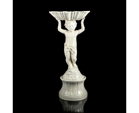 A white ceramic cherub statue that is holding an opened leaf over his head to function as a bird bath with a round base to st