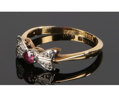 18 carat gold ruby and diamond set ring, the platinum head in the form of a bow with central ruby and diamonds to either side