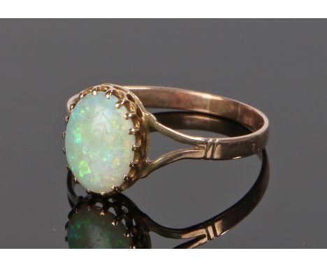 Yellow metal and opal ring, the oval opal set in a pierced crown mount above divided shoulders, ring size R