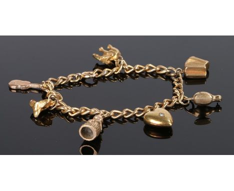 9 carat gold charm bracelet, set with a fox head, elephant, heart violin, figure, lamp and instrument, 15.6 grams