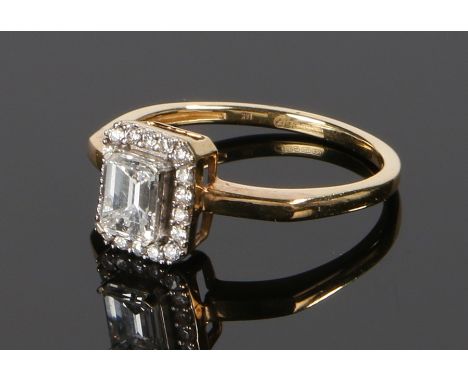 18 carat gold and diamond set ring, the central emerald cut diamond at approximately 0.85 carat G/H colour and VVSI clarity, 