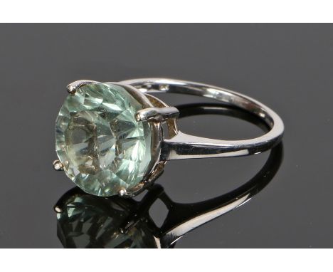 9 carat white gold ring, set with a round cut pale green gemstone, ring size O