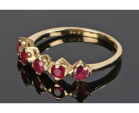 18 carat gold ruby set ring, with a row of five rubies to the head, ring size M 1/2