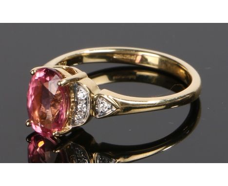 18 carat gold spinel and diamond set ring, the oval pink spinel with diamonds to the shoulders, ring size O