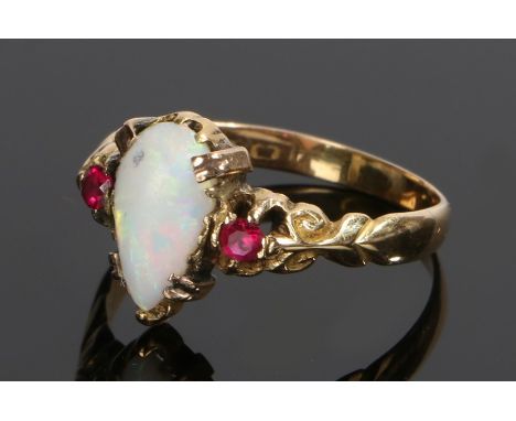 Gold and opal ring, hall marks rubbed, the pear shaped opal set between two rubies, ring size S