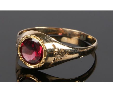 Gold gemstone set ring, with a central red stone sunk into the head, ring size W