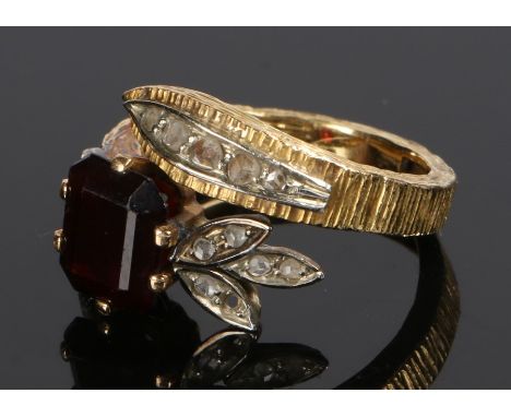 18 carat gold garnet and diamond set ring, the diamond set leaf top above the emerald cut garnet and an arched shank with a d