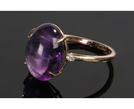 9 carat gold amethyst set ring, the cabochon amethyst flanked by a diamond chip to either side, ring size O