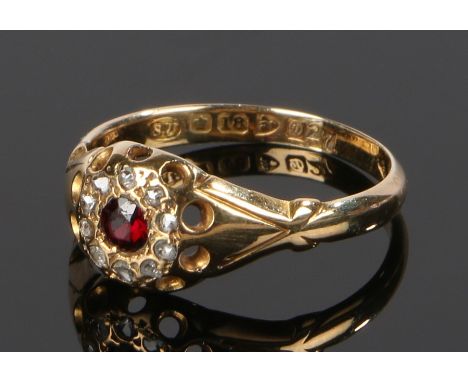 18 carat gold ring, with pierced head and garnet surrounded by diamonds, ring size O 1/2