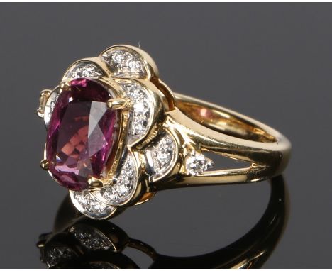 18 carat gold rubellite and diamond set ring, the central oval rubellite with diamonds to the surround and shoulders, ring si