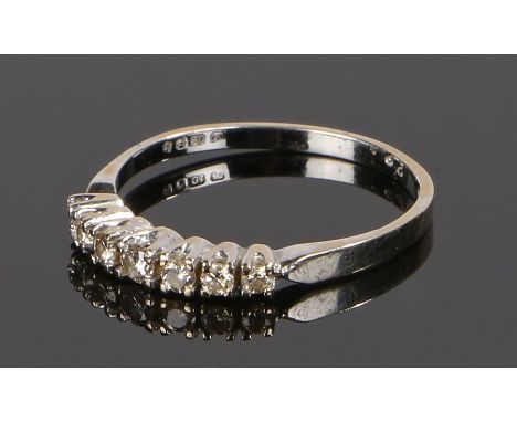 18 carat white gold diamond set ring, with a row of seven round cut diamonds, ring size N