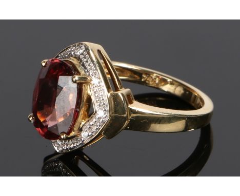 18 carat gold garnet and diamond set ring, the oval facetted garnet with diamonds to the surround, ring size O