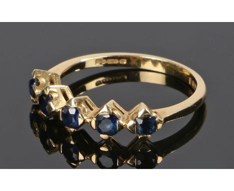 18 carat gold sapphire set ring, with a row of five sapphires to the head, ring size M 1/2