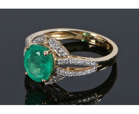 18 carat gold emerald and diamond set ring, with a central emerald with round cut diamond surround and shoulders, ring size O