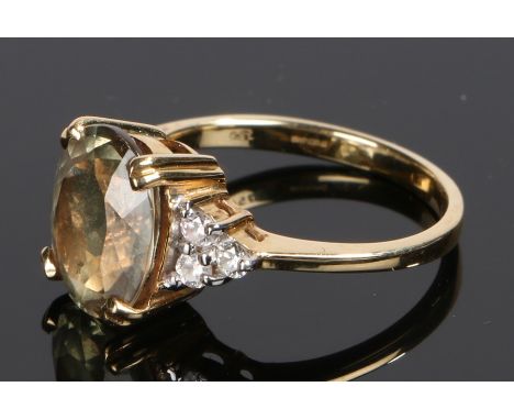 18 carat gold tourmaline set ring, the pale green tourmaline with three diamonds to either shoulder, ring size N