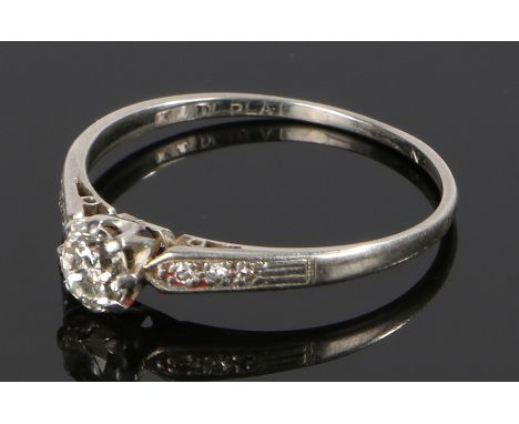 Platinum and diamond set ring, the round cut diamond with three diamonds to either shoulder, ring size R