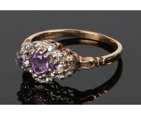 9 carat gold amethyst set ring, the raised head with central amethysts, ring size M