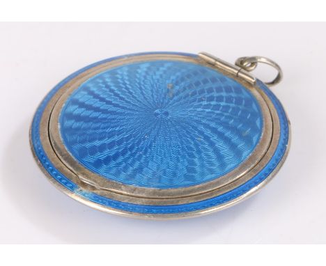 Silver powder compact, of circular form with blue swirled enamel decoration to the exterior, the interior with mirror and gil